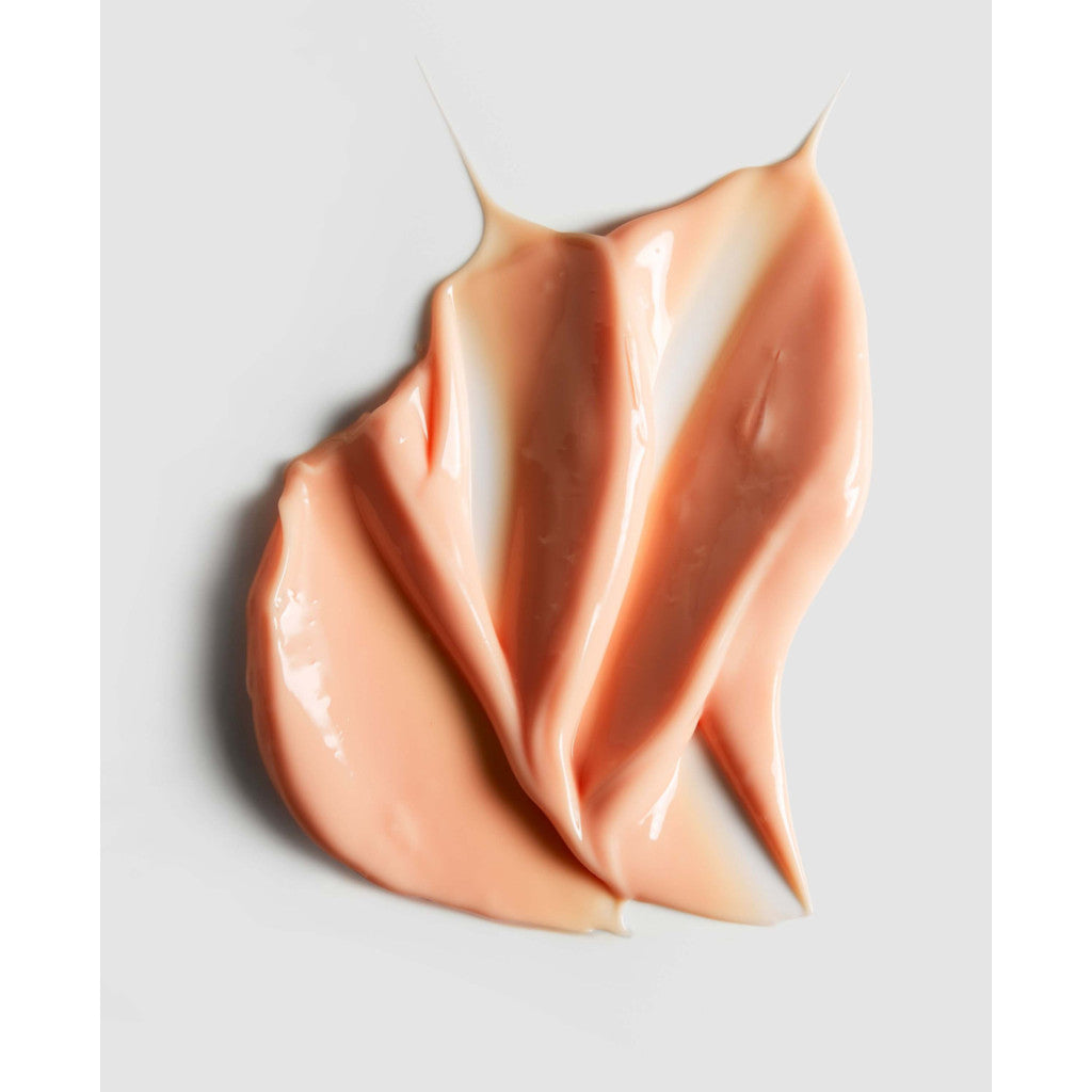 Swirl of peach-colored cream on a light gray background