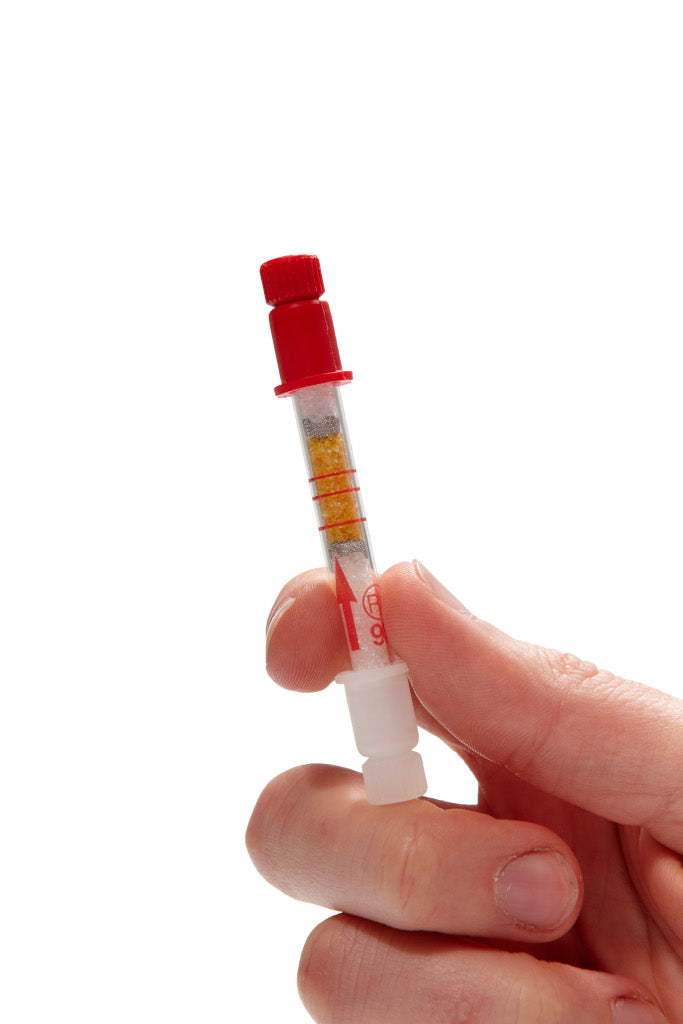 Hand holding a small red and white device with a clear component on a white background