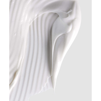 Close-up of white cream or paint with a smooth texture on a light gray background