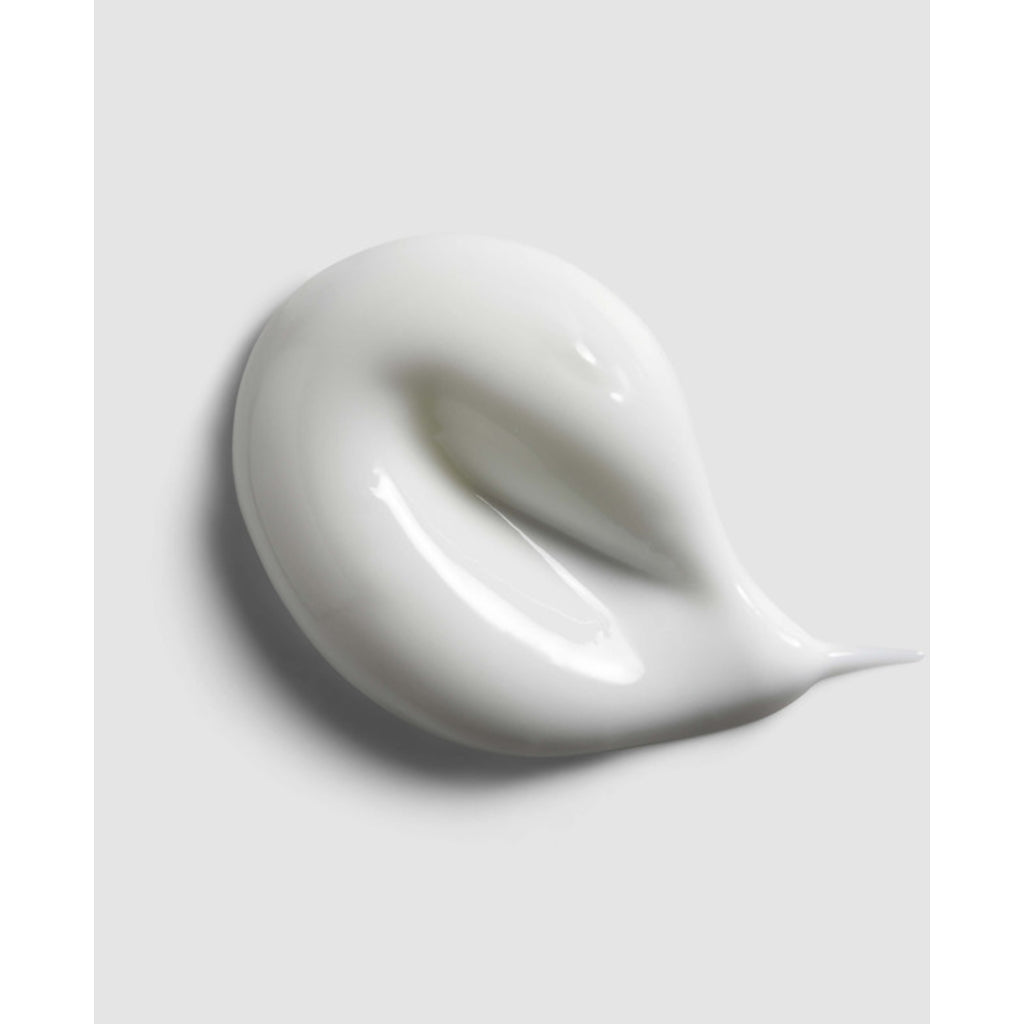 Close-up of a swirl of white cream on a light gray background