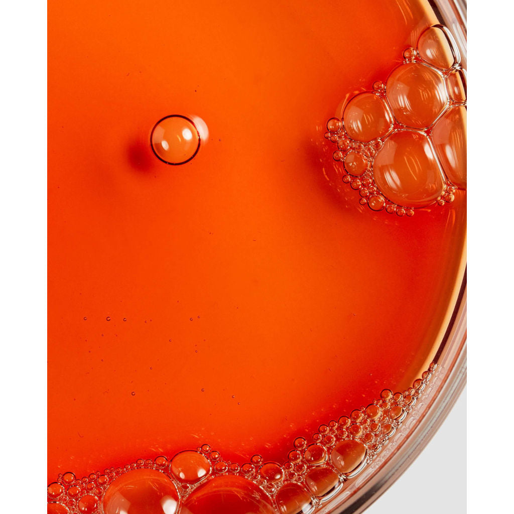 Close-up of a red glass dish with bubbles on a white background