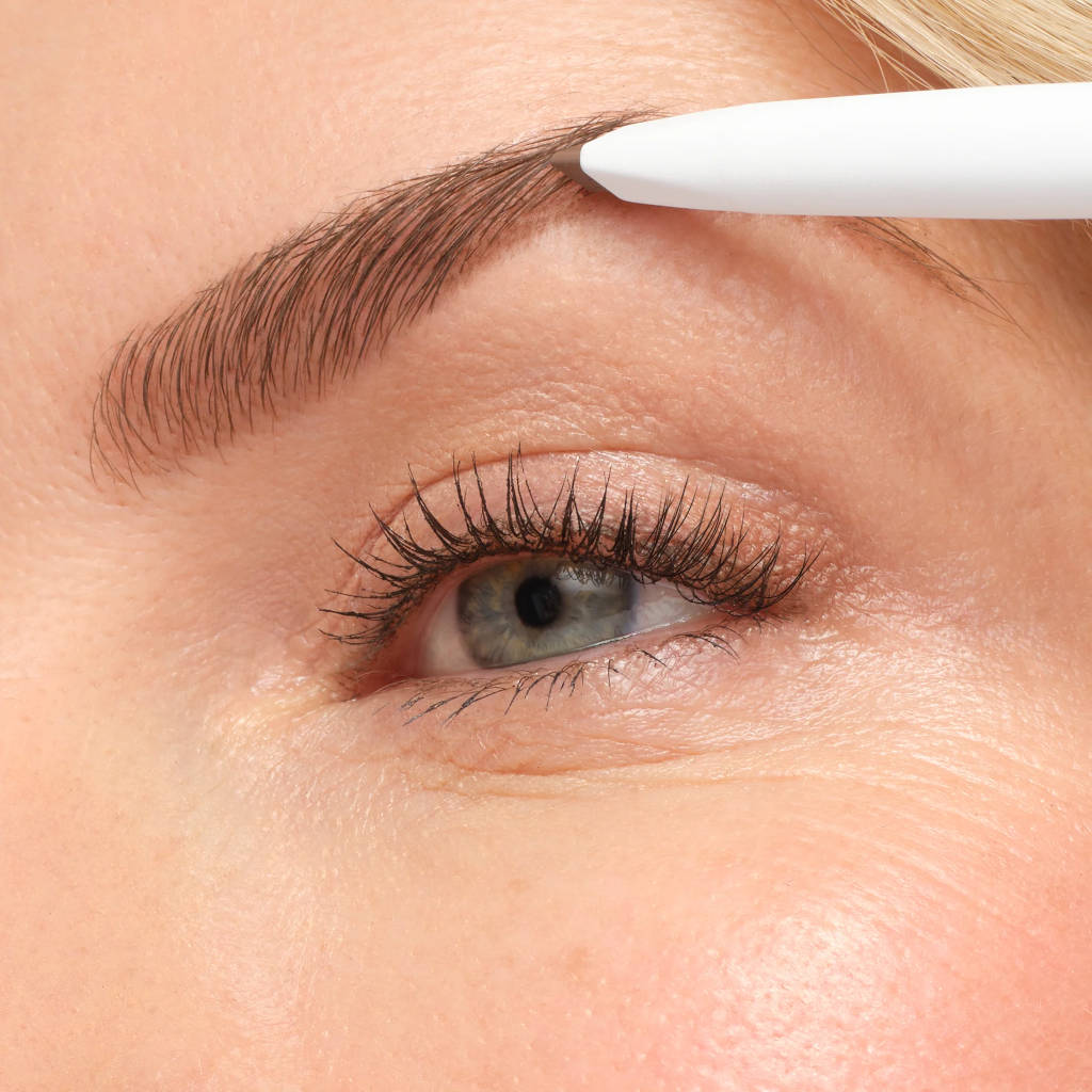Eyebrow pencil being used on a person's eyebrow close-up
