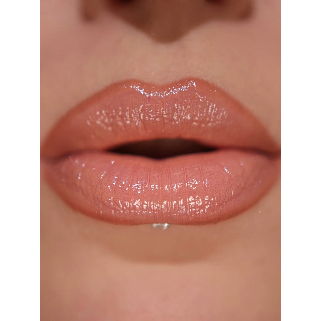Close-up of glossy pink lips with a neutral background