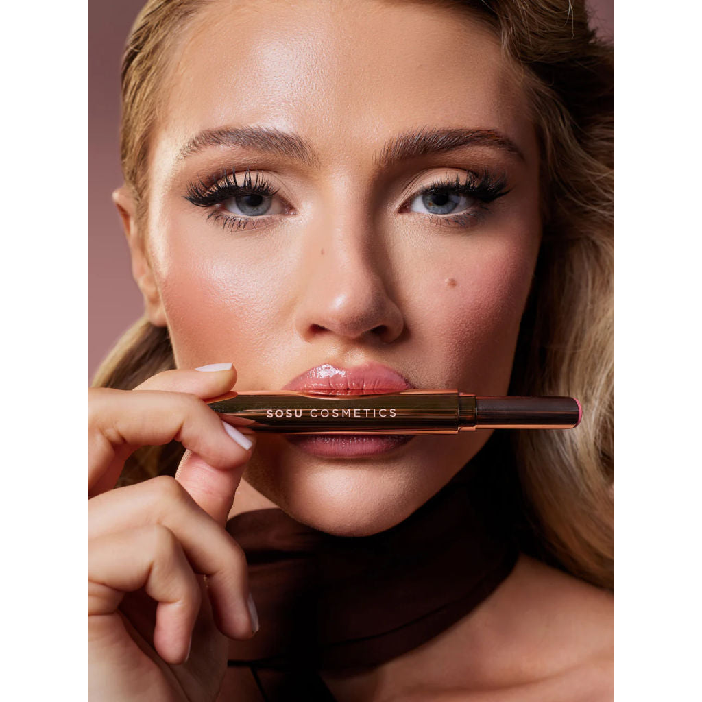 Woman holding a Sosu Cosmetics product close to her face