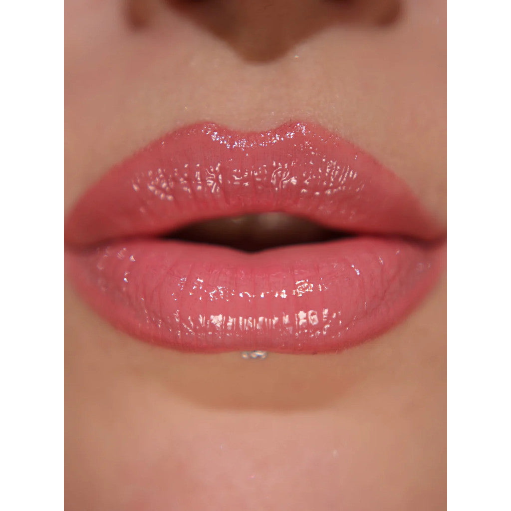 Close-up of glossy pink lips with a neutral background