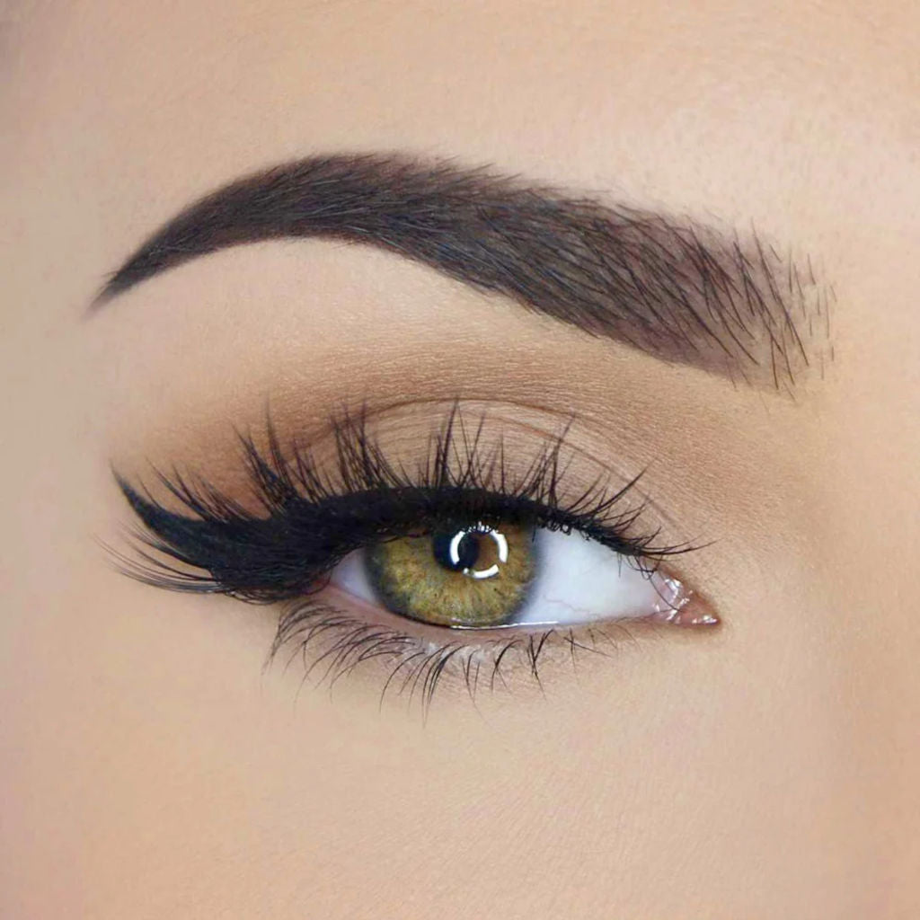 Close-up of an eye with black eyeliner and long lashes on a beige background