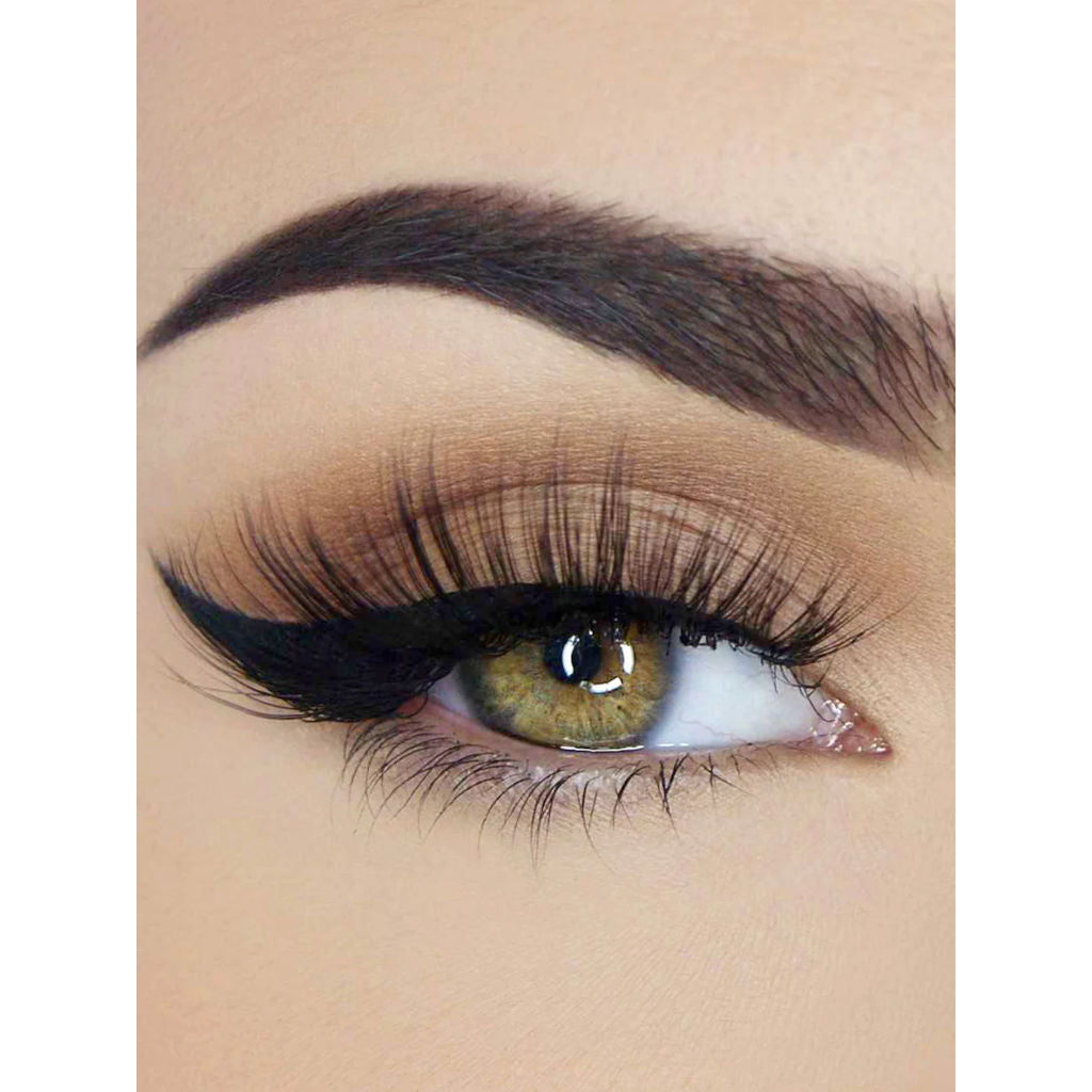 Close-up of an eye with dark eyeliner and long lashes on a beige background
