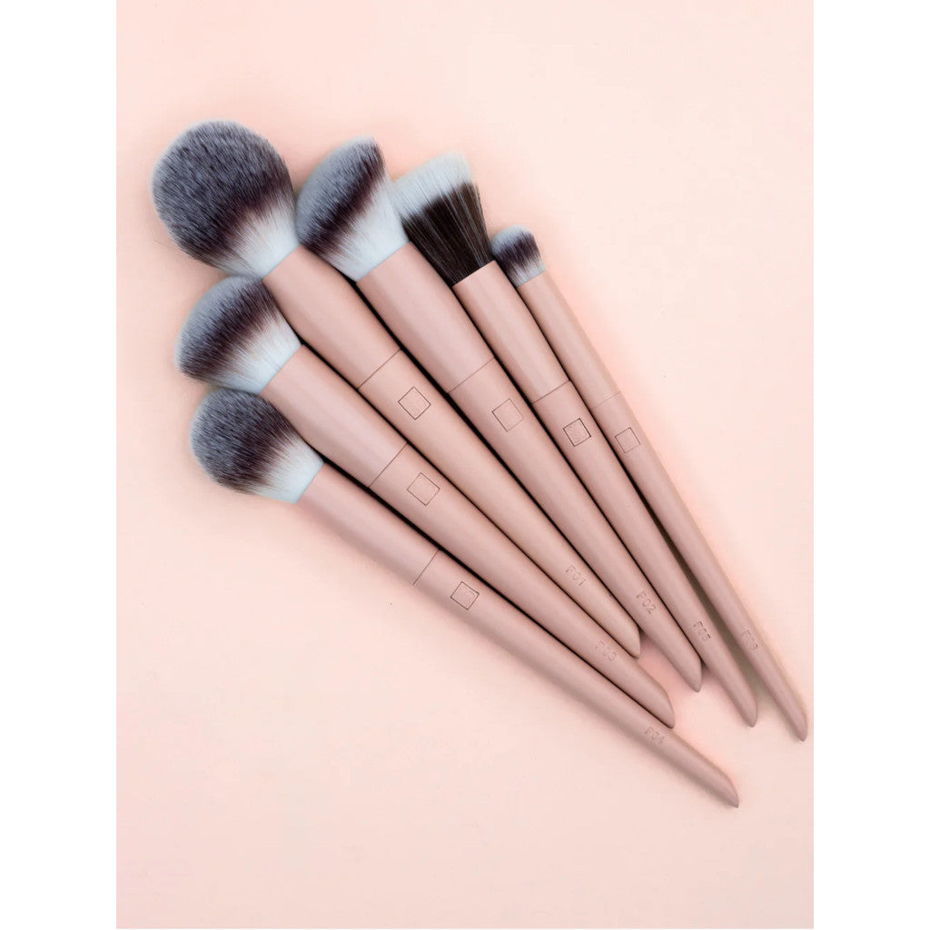 Set of makeup brushes with pink handles on a light pink background